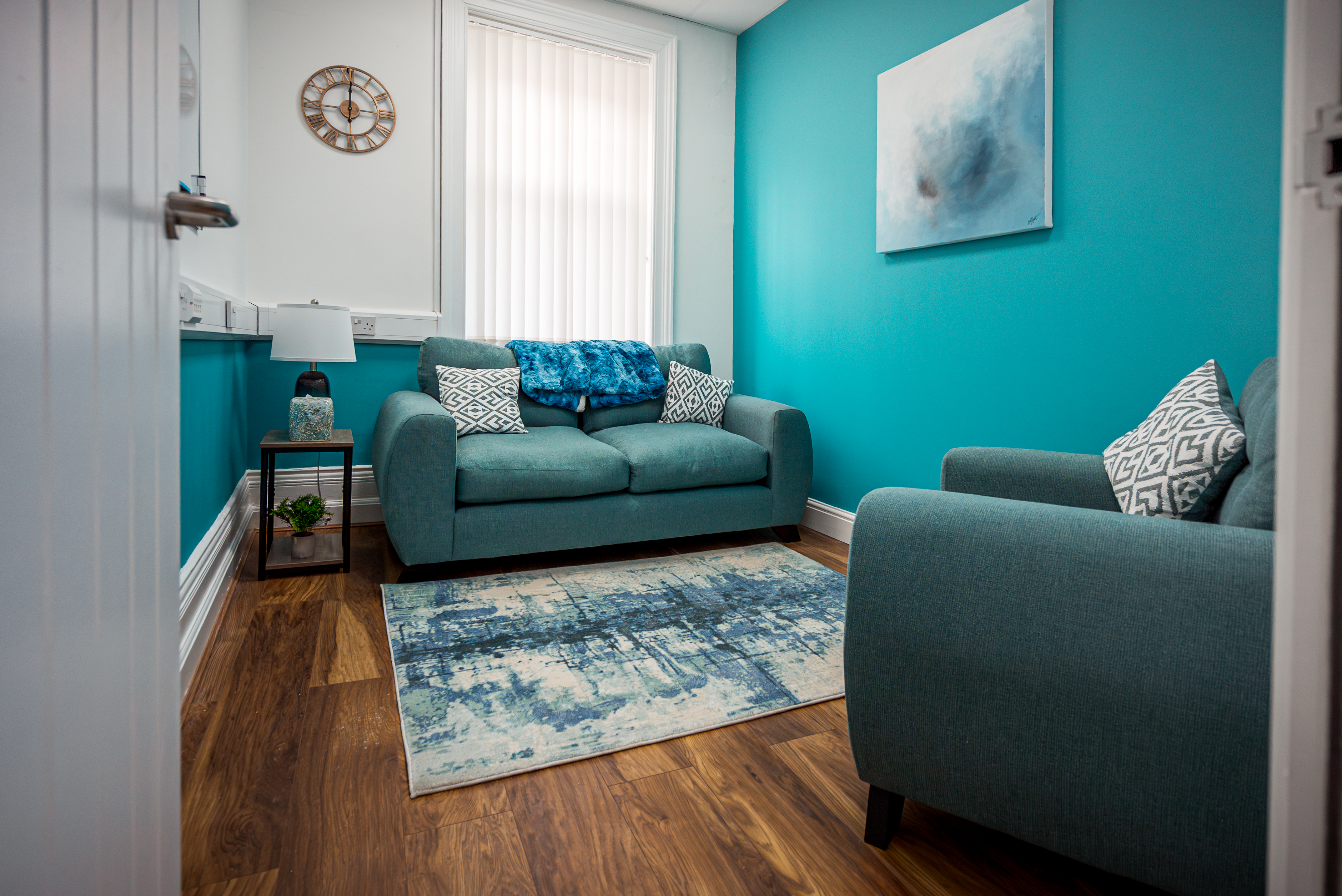 Calm, welcoming therapy room in teal and white